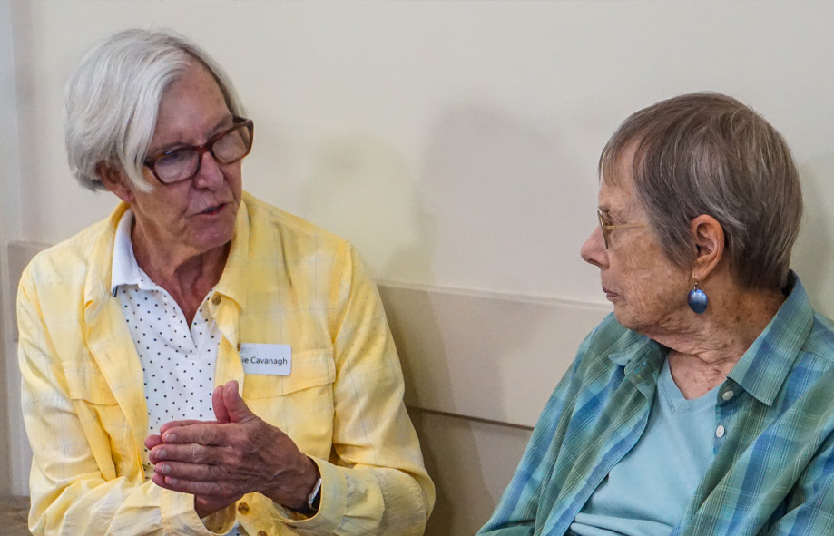 A retirement home resident listens intently as a volunteer chats with them.