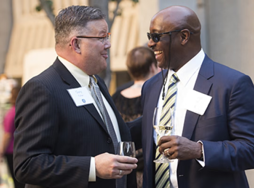 A donor speaking with a development officer at a donor recognition event.