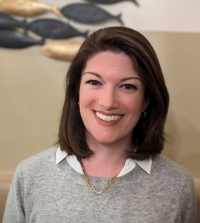 Headshot of Leslie Fitzpatrick smiling in a grey sweater.