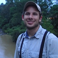 Daniel Karp wearing a cap in front of a watershed.